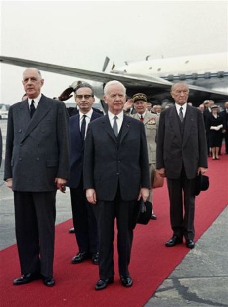 Heinrich Lübke mit Charles de Gaulle und Bundeskanzler Adenauer auf dem roten Teppich vor einem Flugzeug